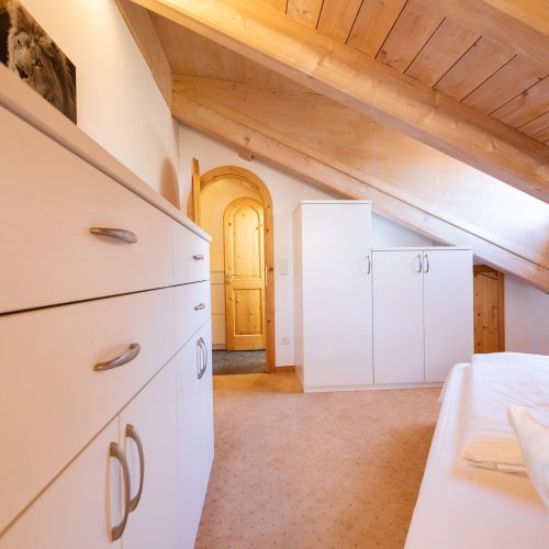 Bett und Schrank unter Dachschräge in Ferienwohnung in Garmisch-Partenkirchen