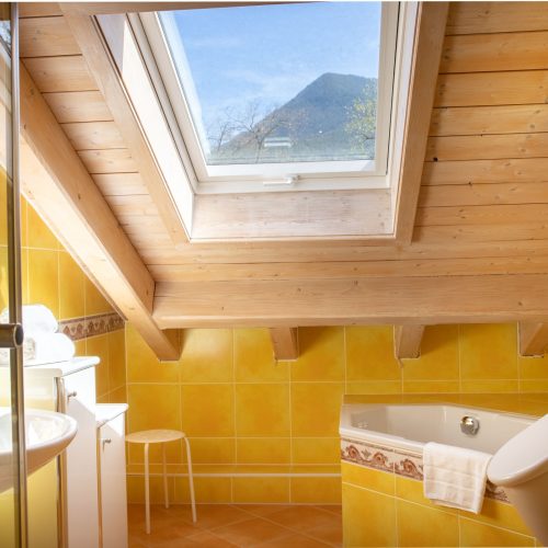 Gelbes Badezimmer mit Dachfenster in Ferienwohnung in Garmisch-Partenkirchen