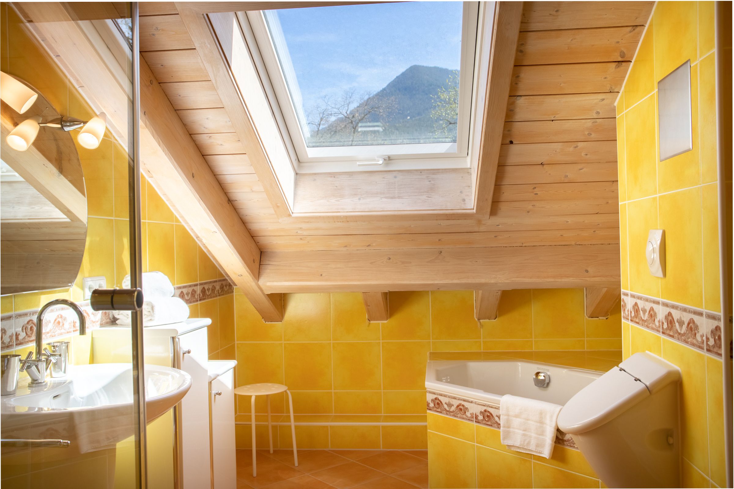 Gelbes Badezimmer mit Dachfenster in Ferienwohnung in Garmisch-Partenkirchen