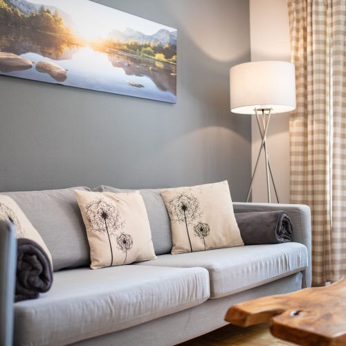 Sofa mit Blumenkissen in Ferienwohnung in Garmisch-Partenkirchen
