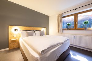 Doppelbett im Schlafzimmer mit schönem Ausblick in Ferienwohnung in Garmisch-Partenkirchen
