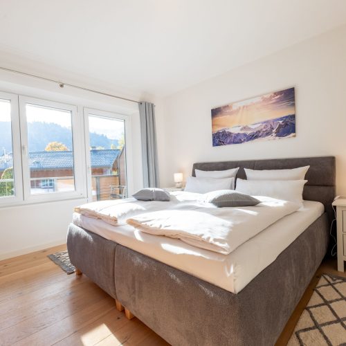 Doppelbett und Wandbild in Ferienwohnung in Garmisch-Partenkirchen