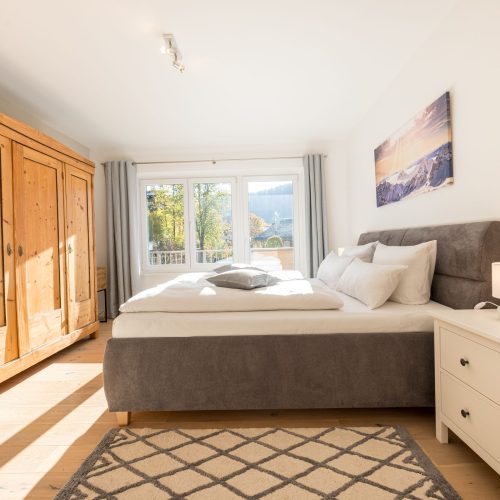 Doppelbett und großer Holzschrank in Ferienwohnung in Garmisch-Partenkirchen