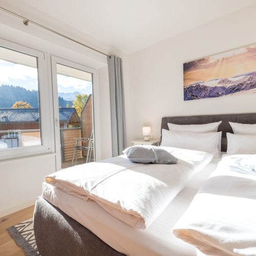 Blick übers Bett zum Fenster hinaus in Ferienwohnung in Garmisch-Partenkirchen