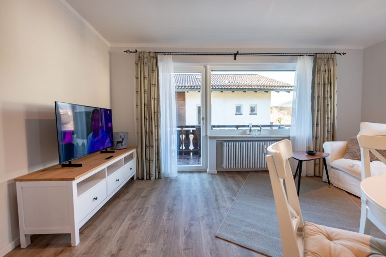 Blick aus den Wohnbereich auf Fernseher und Balkon