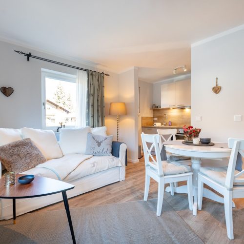 Wohnbereich mit Holzherzen an der Wand in Ferienwohnung in Garmisch-Partenkirchen