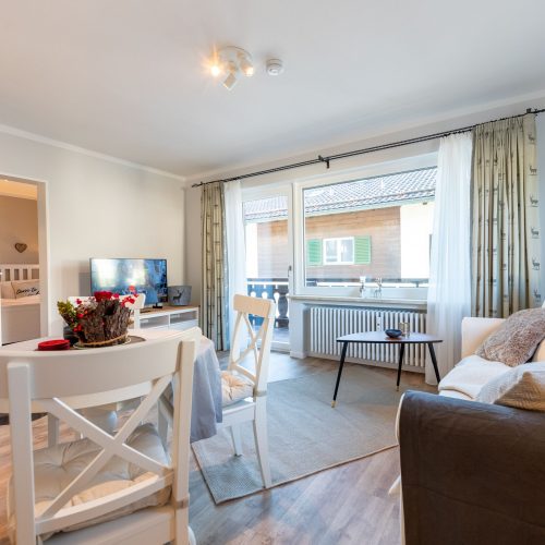 Wohnbereich mit Fernseher, Sofa und Beistelltisch in Ferienwohnung in Garmisch-Partenkirchen