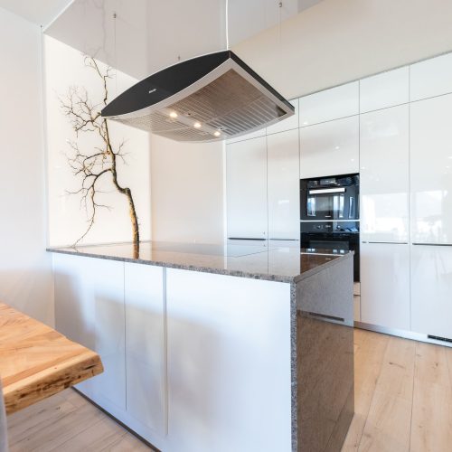 Weiß-helle Küche mit Kücheninsel in Ferienwohnung in Garmisch-Partenkirchen