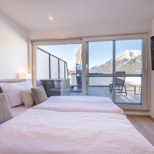 Doppelbett mit pinker Decke in Ferienwohnung in Garmisch-Partenkirchen