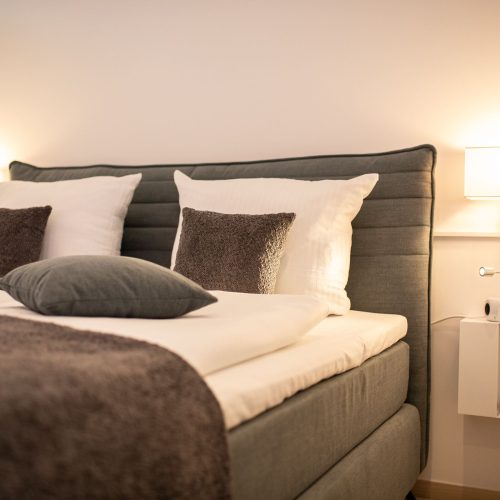 Boxspringbett für zwei Personen und kleinen Nachtschränken in Ferienwohnung in Garmisch-Partenkirchen