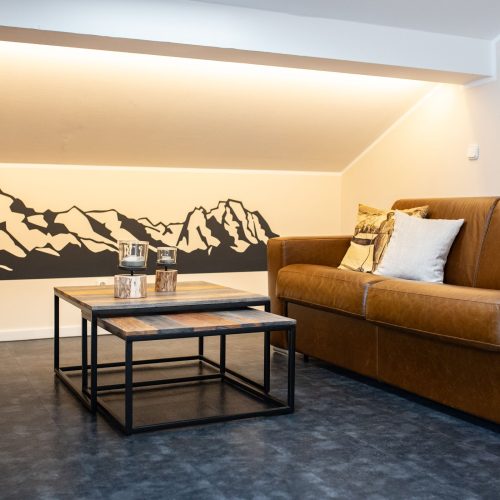 Wohnzimmer mit braunem Sofa in Ferienwohnung in Garmisch-Partenkirchen