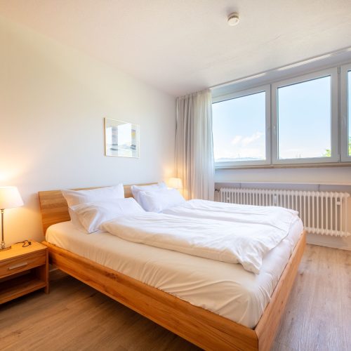Schlafzimmer mit Holzbett in Ferienwohnung in Garmisch-Partenkirchen
