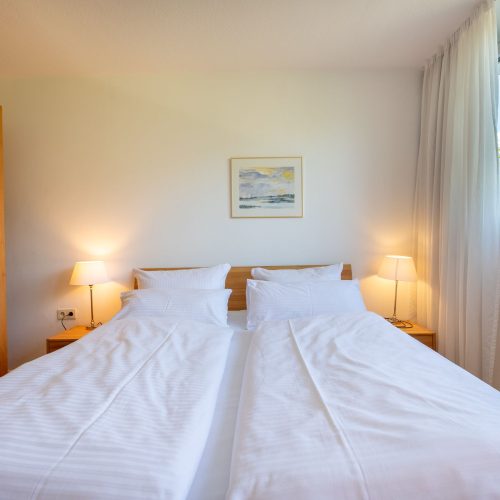 Holzbett und zwei Nachtschränke in Ferienwohnung in Garmisch-Partenkirchen