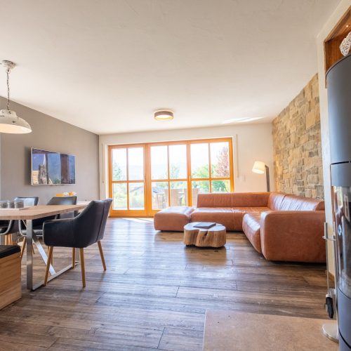 Wohnbereich mit offenem Essbereich, einem Kamin und einem braunen Sofa