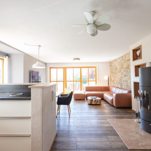 Wohnbereich mit Deckenventilator und Kamin in Ferienwohnung in Garmisch-Partenkirchen