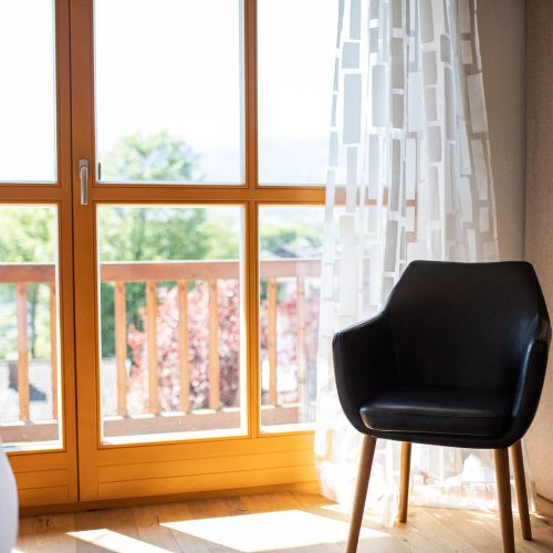 Sitzmöglichkeit im Schlafzimmer mit Großen Fenstern und Zugang zum Balkon in Ferienwohnung in Garmisch-Partenkirchen