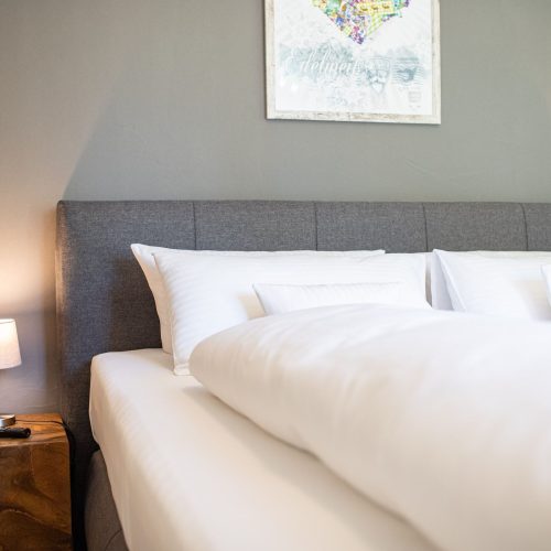 Doppelbett mit braunem Nachtschrank in Ferienwohnung in Garmisch-Partenkirchen