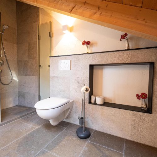 Badezimmer mit Steinoptik Wänden und Dekoration in Ferienwohnung in Garmisch-Partenkirchen