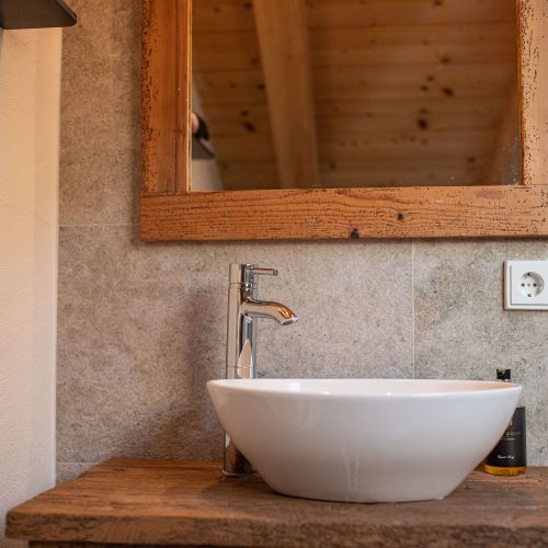 Waschbecken auf einem Holz-Optik Schrank mit Spiegel in Ferienwohnung in Garmisch-Partenkirchen