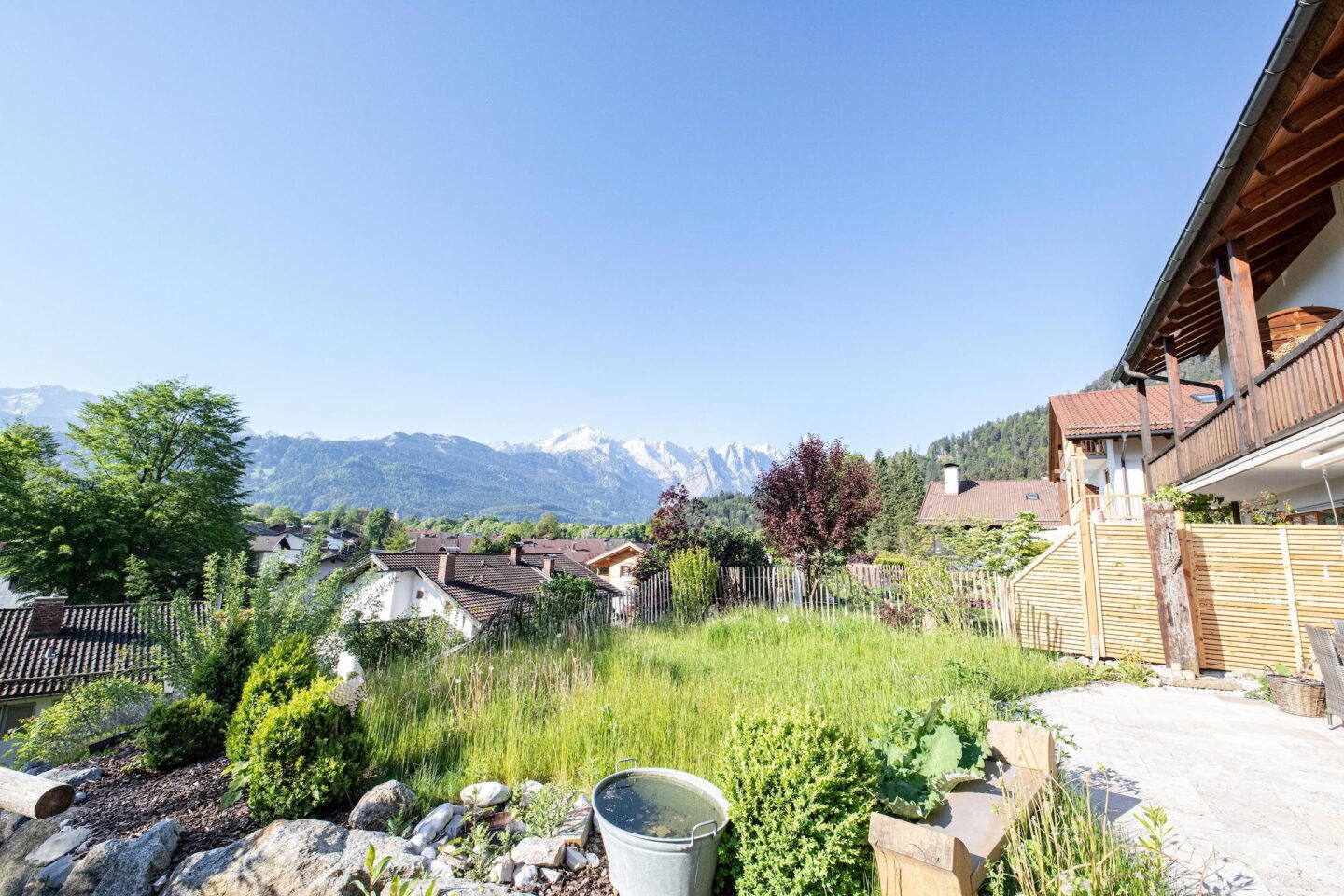 Ausblick auf den Außenbereich mit einer Terrasse und einem Rasenstück in Ferienwohnung in Garmisch-Partenkirchen