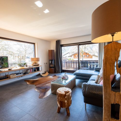 Wohnzimmer mi schwarzem Sofa in Ferienwohnung in Garmisch-Partenkirchen