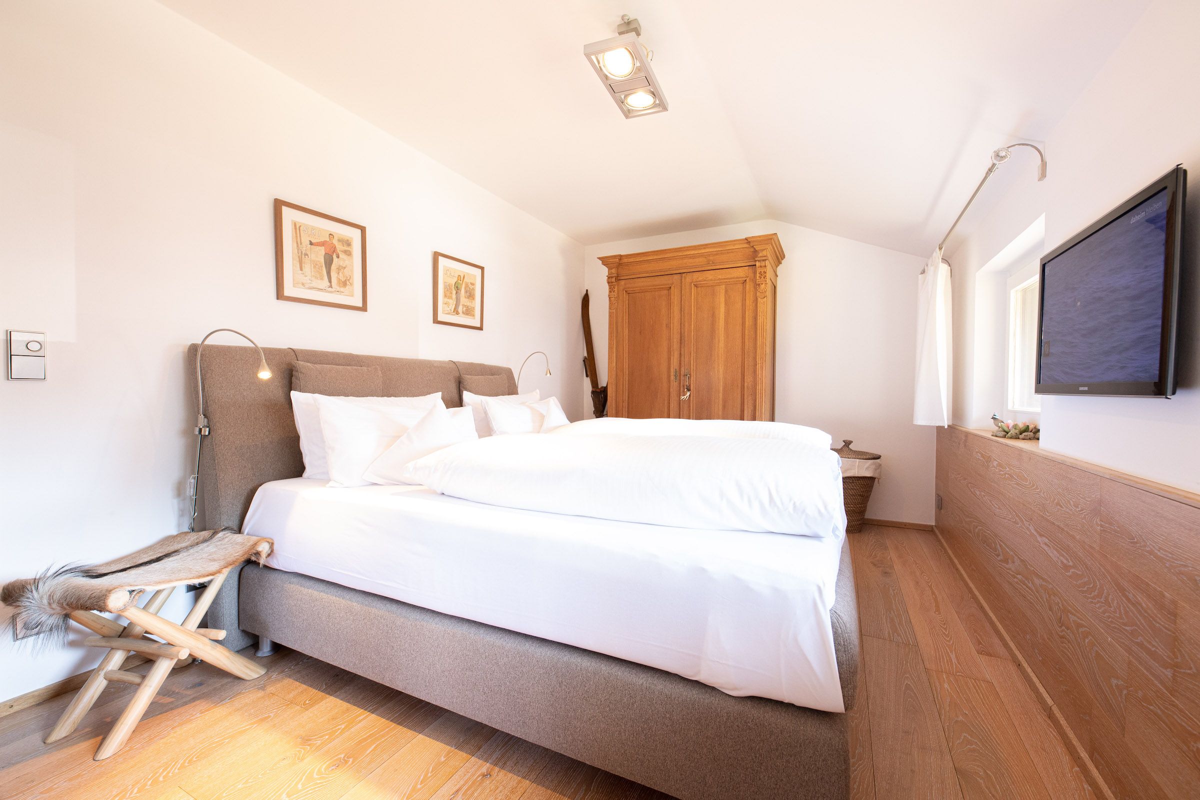 Doppelbett mit Sitzmöglichkeit und Kleiderschrank in Ferienwohnung in Garmisch-Partenkirchen