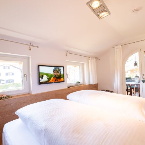 Doppelbett mit Fernseher in Ferienwohnung in Garmisch-Partenkirchen
