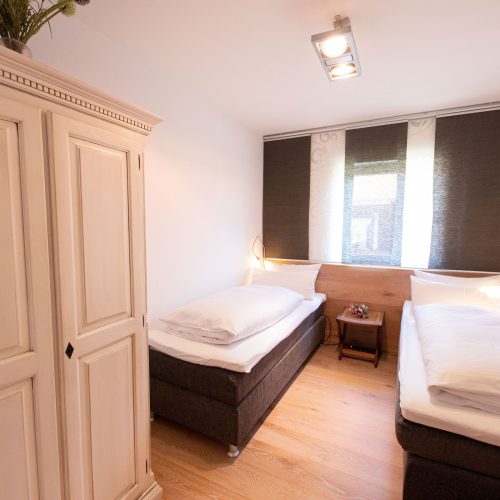 zwei Einzelbetten mit Kleiderschrank in Ferienwohnung in Garmisch-Partenkirchen