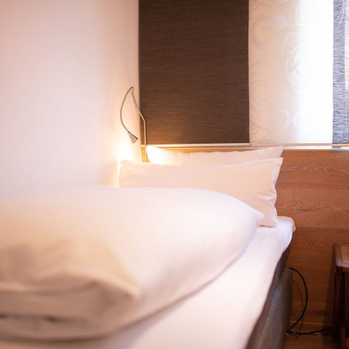 Einzelbett mit kleinem Licht in Ferienwohnung in Garmisch-Partenkirchen