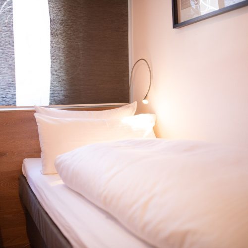 Einzelbett mit kleinem Licht in Ferienwohnung in Garmisch-Partenkirchen