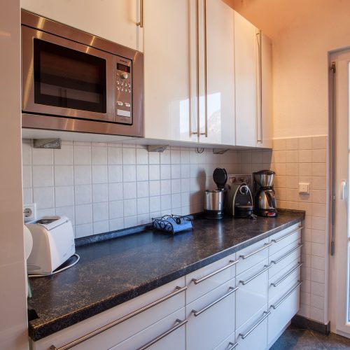 Küche mit dunkler Arbeitsplatte in Ferienwohnung in Garmisch-Partenkirchen