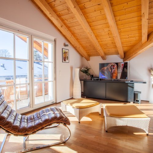 Wohnzimmer mit Hockern und Fernsehre in Ferienwohnung in Garmisch-Partenkirchen