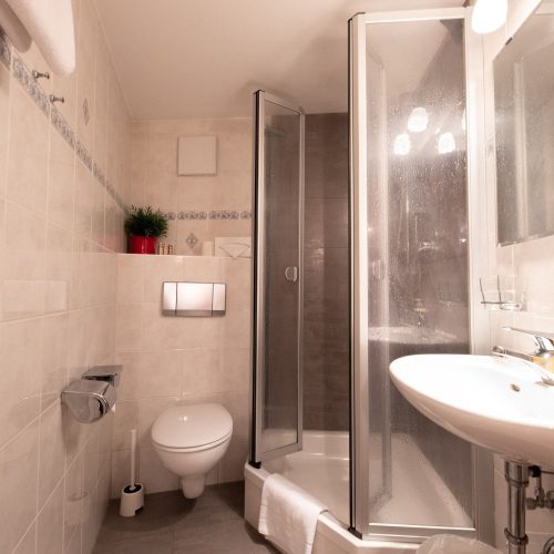 Badezimmer mit Dusche und Spiegel in Ferienwohnung in Garmisch-Partenkirchen