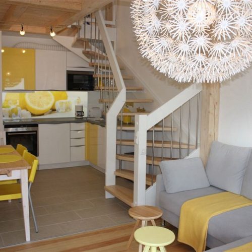 Wohnbereich mit hellgrauem Sofa und Esstisch in Ferienwohnung in Garmisch-Partenkirchen