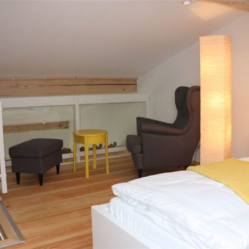 Sessel und Doppelbett in Ferienwohnung in Garmisch-Partenkirchen