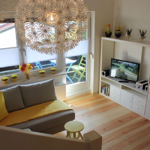 Wohnzimmer mit Fernseher und Balkon in Ferienwohnung in Garmisch-Partenkirchen