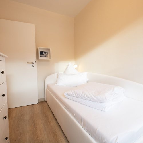 Einzelbett mit Wanddekoration in Ferienwohnung in Garmisch-Partenkirchen