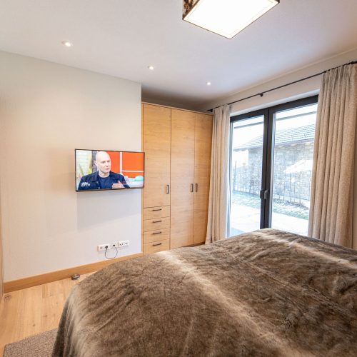 Doppelbett mit Fernseher in Ferienwohnung in Garmisch-Partenkirchen