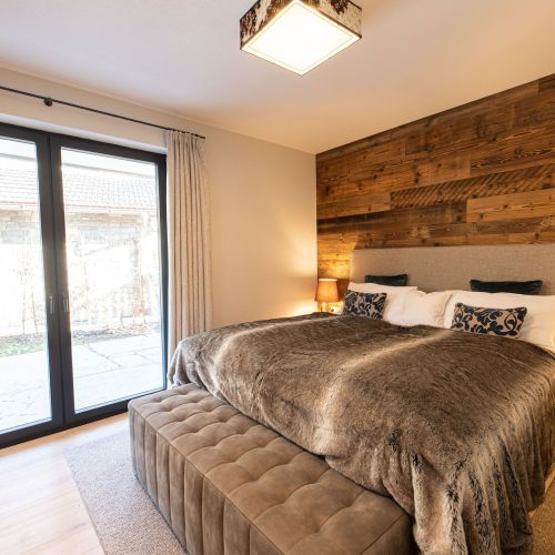 Doppelbett mit Fenster in Ferienwohnung in Garmisch-Partenkirchen