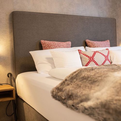 Doppelbett mit Nachttisch in Ferienwohnung in Garmisch-Partenkirchen