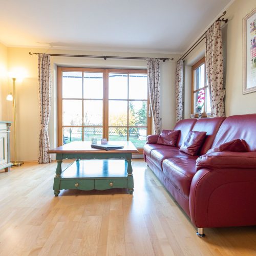 rotes Sofa mit Couchtisch in Ferienwohnung in Garmisch-Partenkirchen