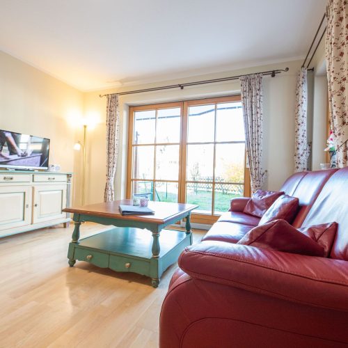 rotes Sofa mit Fernseher in Ferienwohnung in Garmisch-Partenkirchen