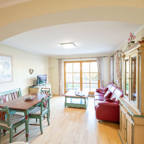 Wohnbereich mit Fernseher und Sofa in Ferienwohnung in Garmisch-Partenkirchen