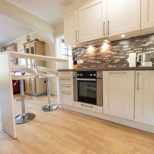 Küche mit weißen Schränken in Ferienwohnung in Garmisch-Partenkirchen