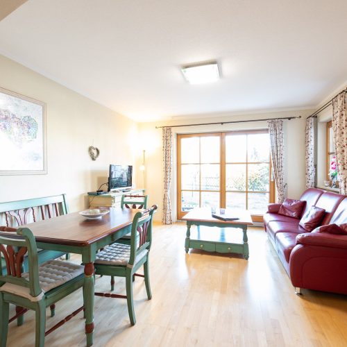 rotes Sofa und Türkise Stühle in Ferienwohnung in Garmisch-Partenkirchen