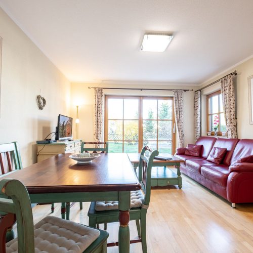 Esszimmer und Wohnzimmer mit Sofa und Stühlen in Ferienwohnung in Garmisch-Partenkirchen