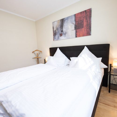 Doppelbett in schwarz und Bild übern Bett in Ferienwohnung in Garmisch-Partenkirchen