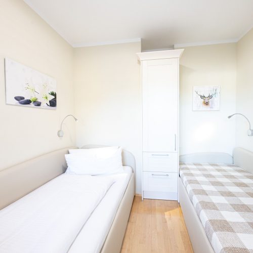 zwei Einzelbetten und schmalen Schrank in Ferienwohnung in Garmisch-Partenkirchen