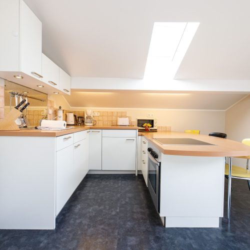 Küche mit Dachfenster und Stühlen in Ferienwohnung in Garmisch-Partenkirchen