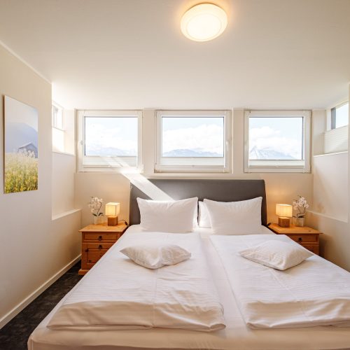 Doppelbett mit Nachttisch in Ferienwohnung in Garmisch-Partenkirchen